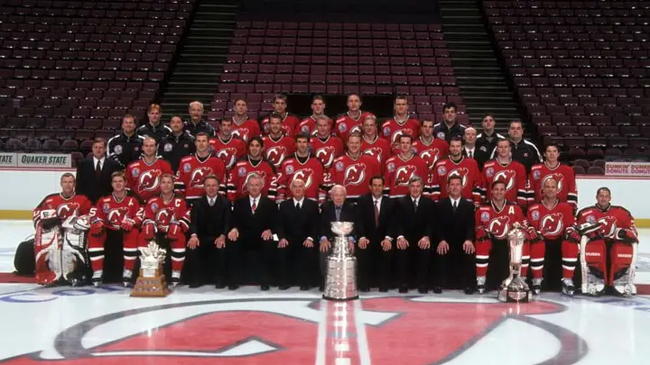 New Jersey Devils players celebrating with the Stanley Cup after clinching the 2000 championship on the ice