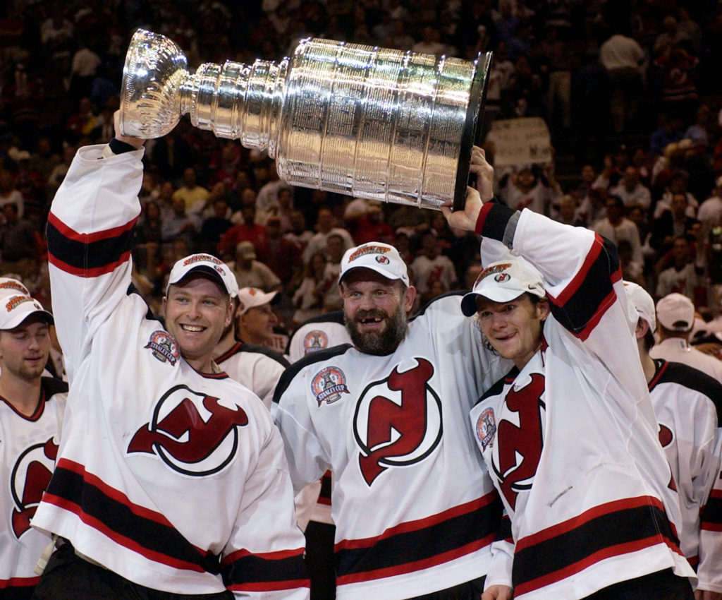 New Jersey Devils players lifting the 2003 Stanley Cup amid confetti at celebration on ice