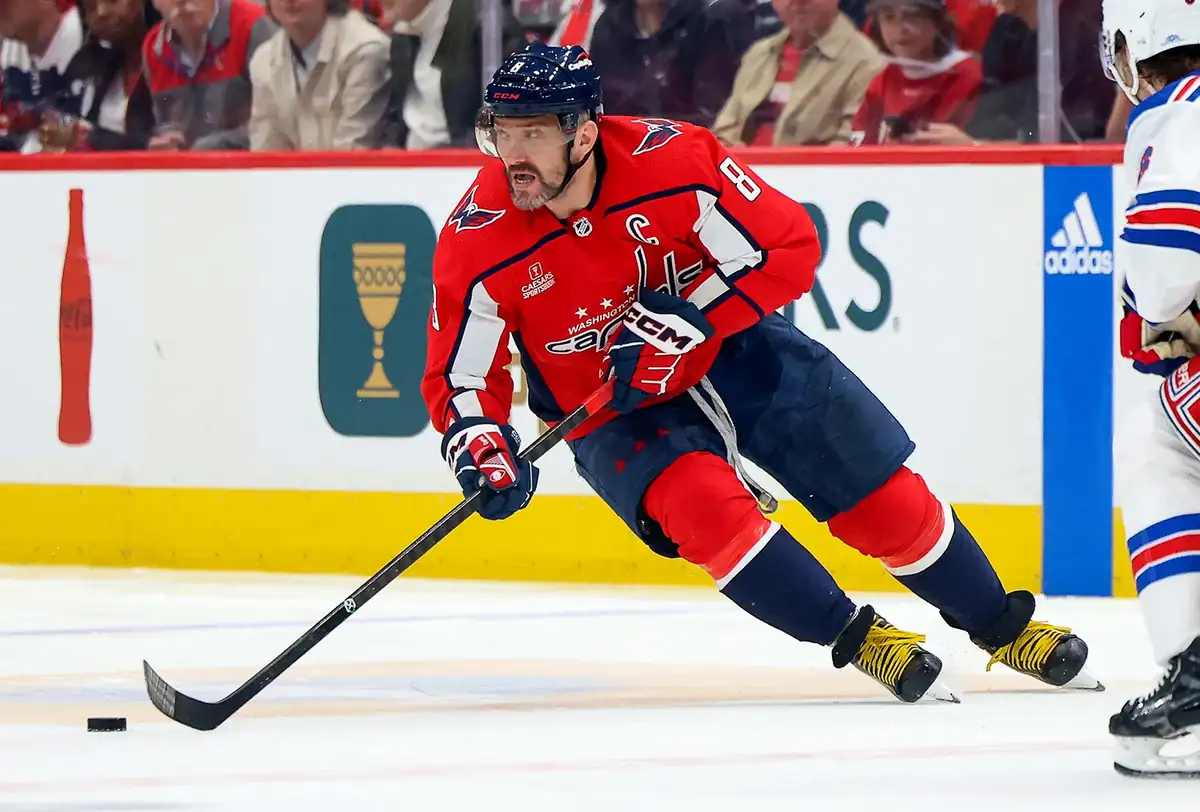 Alexander Ovechkin raising his arms in celebration after scoring a goal with Washington Capitals jersey