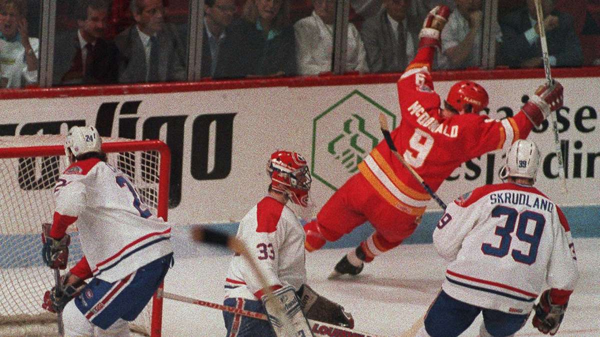 1989 Calgary Flames team photo on the ice with players lined up wearing red jerseys and the Stanley Cup celebration…