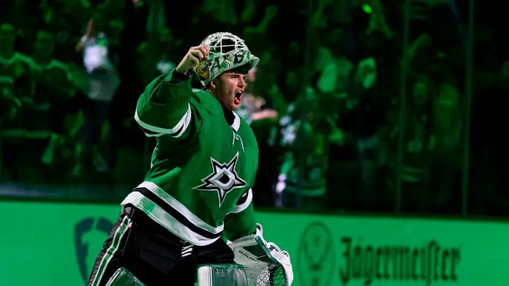Dallas Stars forward battling for the puck during a fast-paced NHL game with crowd in background