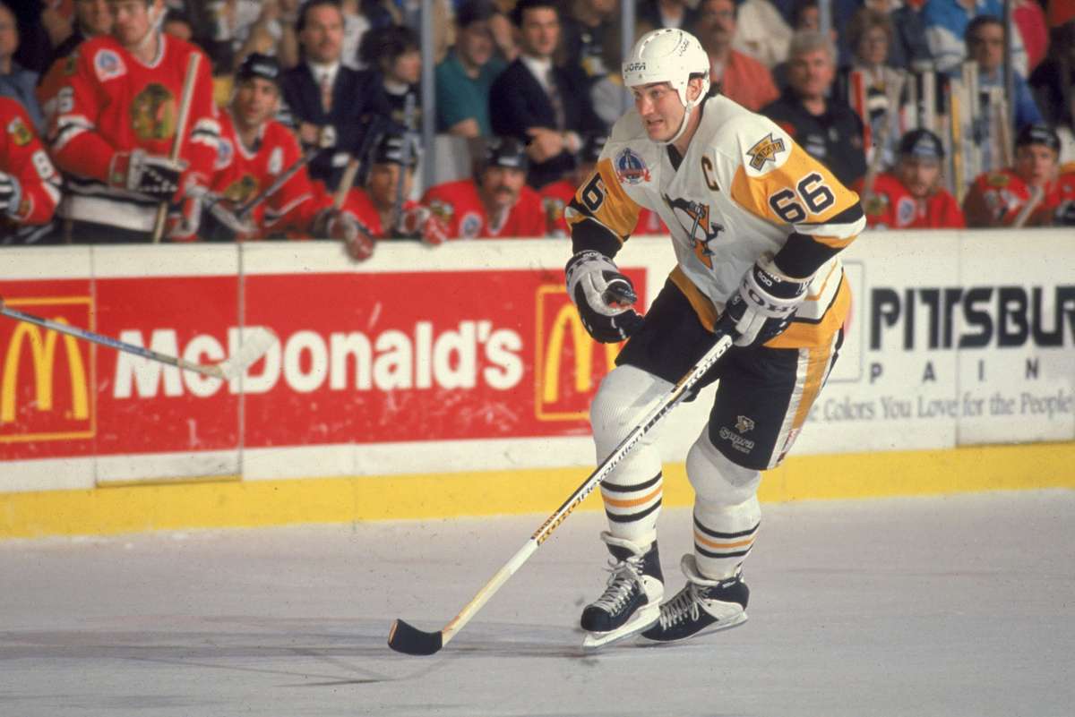 Mario Lemieux in Penguins uniform as a young rookie skating with the puck during an early NHL game