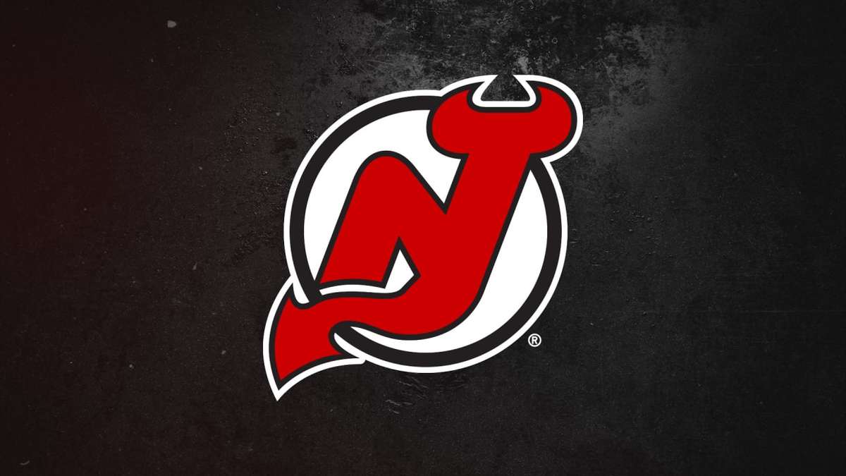 Devils fans arriving at Newark Penn Station wearing red and black jerseys and scarves before a home game