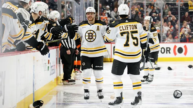 David Pastrnak raising his stick and celebrating after scoring at TD Garden against the Vegas Golden Knights
